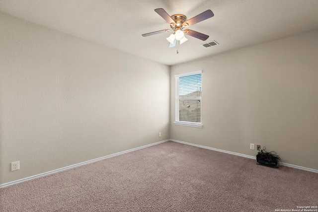 an empty room with a fan and a window
