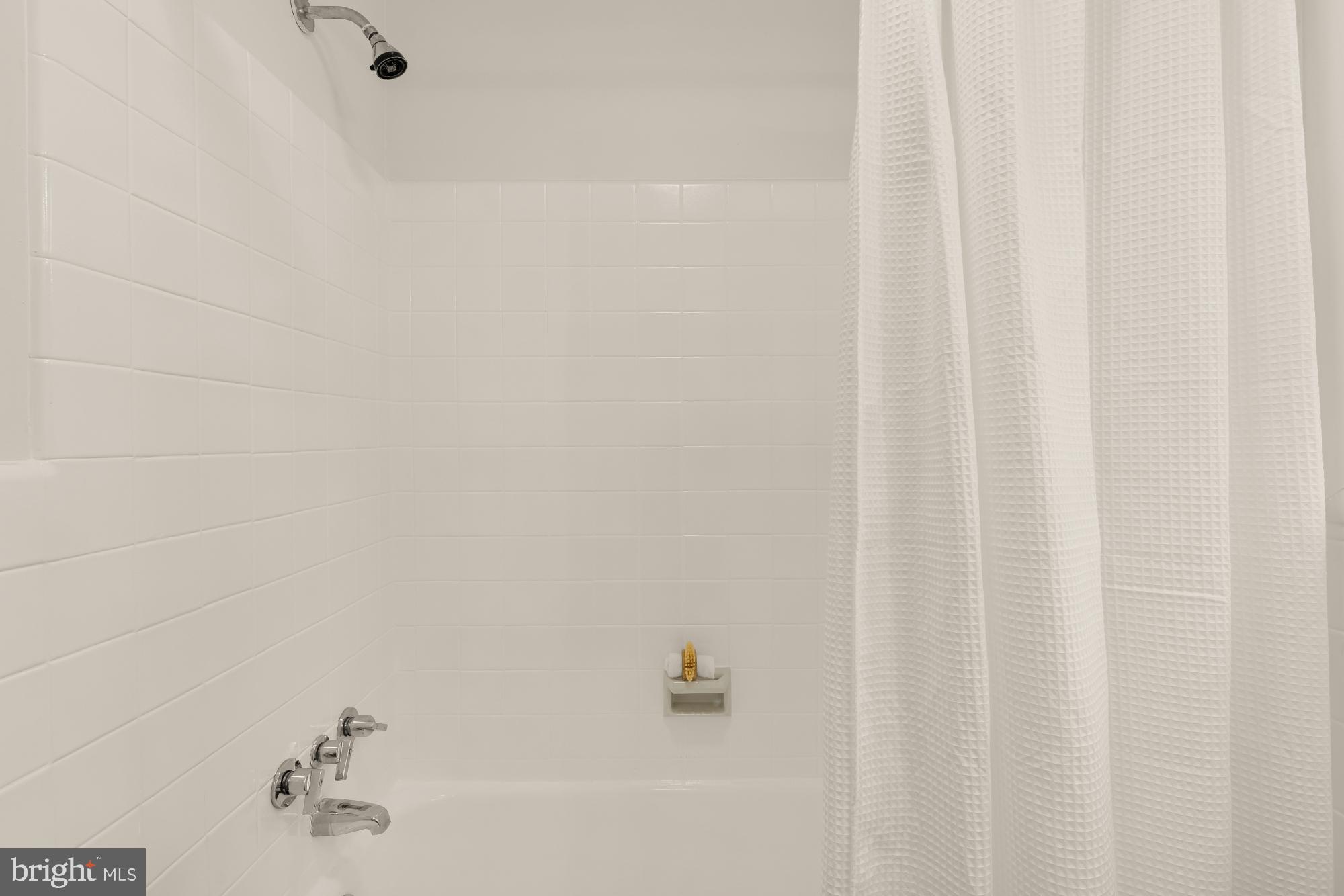 4911 Falstone Avenue Chevy Chase, MD 20815 - Photo 32 of 58 a bathroom with a shower curtain