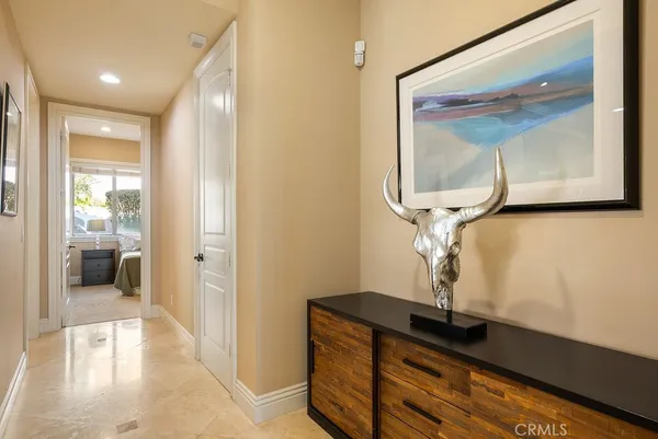 a view of hallway with a mirror and vanity