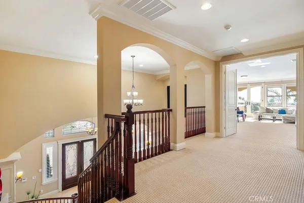 a view of a hallway with furniture and a chandelier