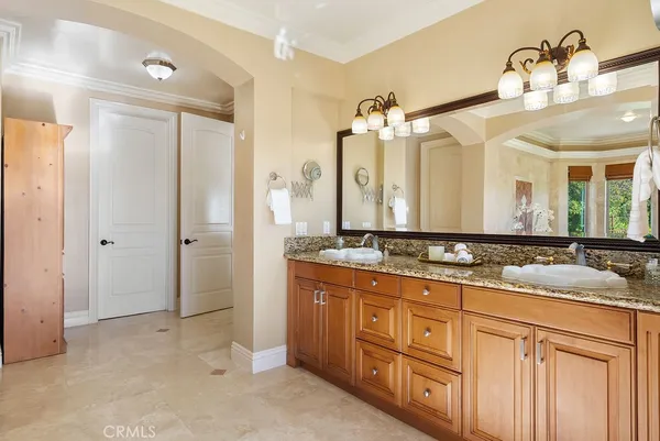 a bathroom with a granite countertop sink two mirror and a shower