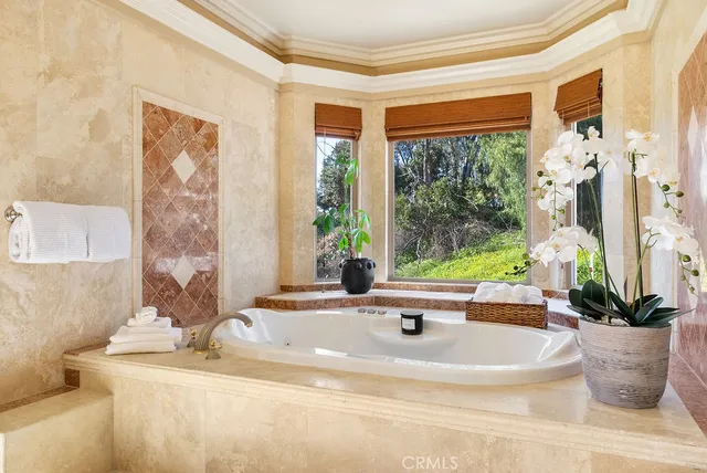 a white bath tub sitting in a bathroom next to a window