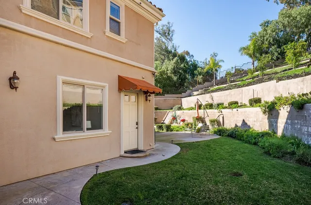 a view of a house with a yard and potted plants