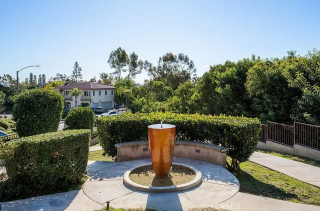 a backyard of a house with fountain table and chairs