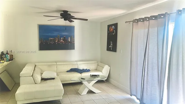 a living room with furniture and a ceiling fan