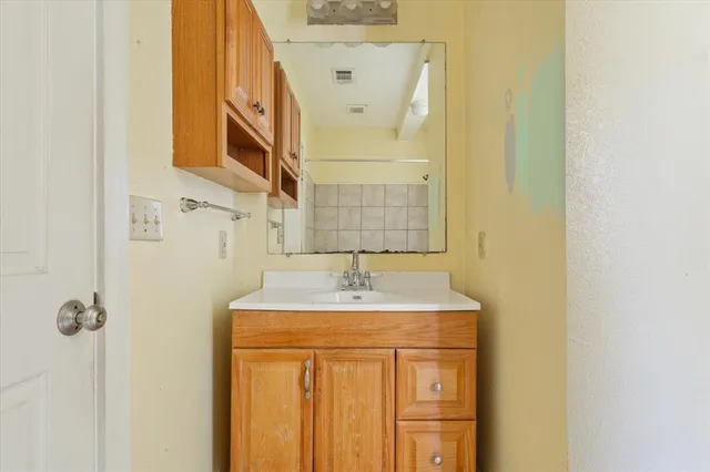 a bathroom with a granite countertop sink and a mirror