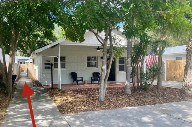 a view of a house with backyard and trees