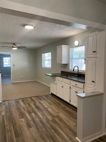 a kitchen with granite countertop a sink and cabinets