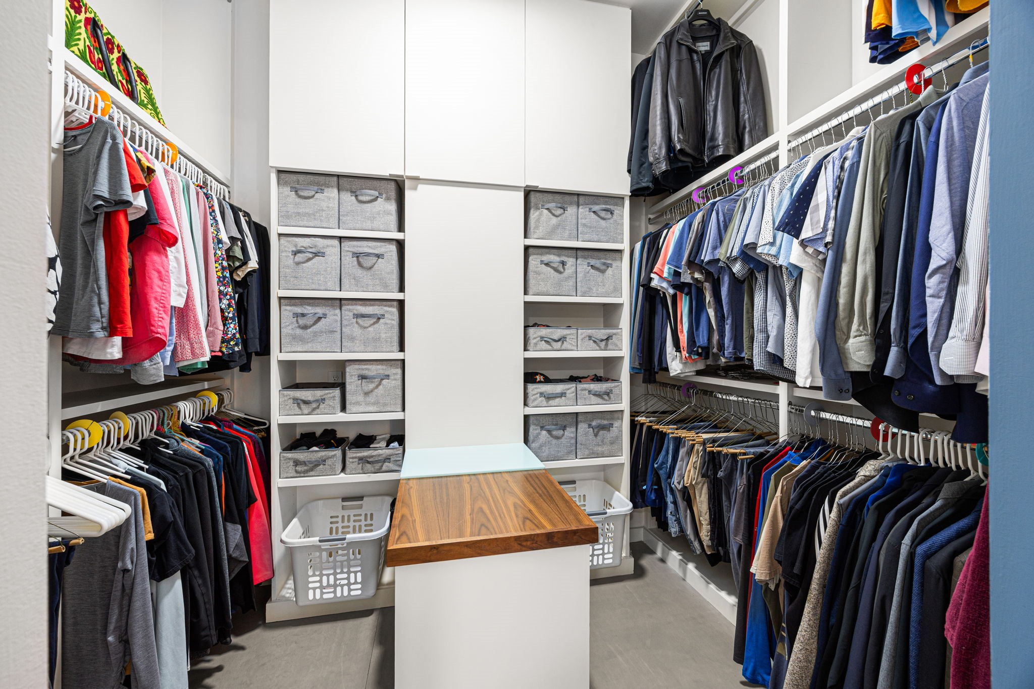5811 Rose Street Houston, TX 77007 - Photo 22 of 38 Space is thoughtfully maximized in the primary closet. Two walls of floor-to-ceiling hanging space, as well as a wall of bin storage eliminates the need for a dresser. The luggage/prep counter allows a central location to prep for the next day.