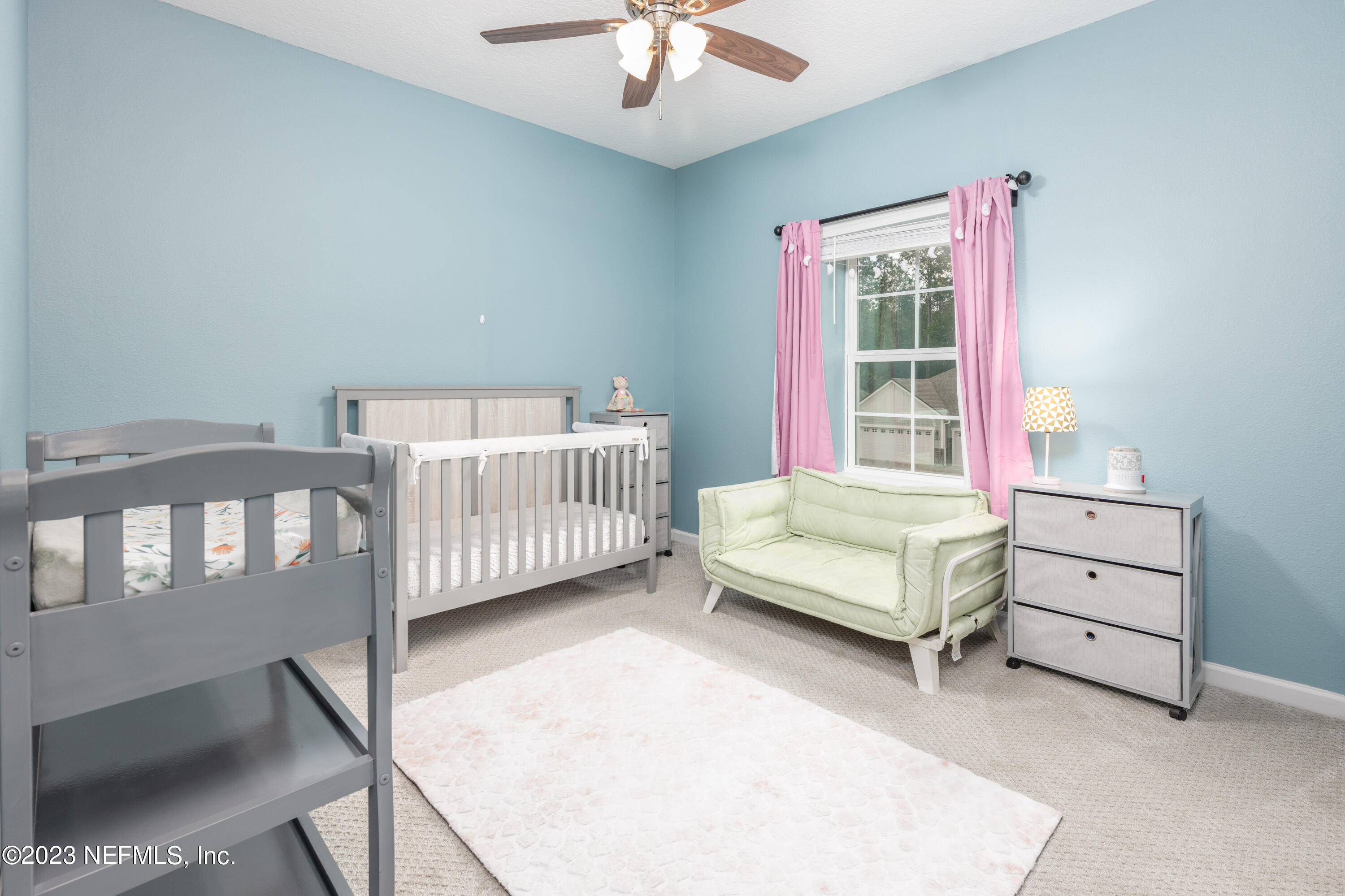 400 Weathered Edge Drive St. Augustine, FL 32092 - Photo 16 of 35 a bedroom with a bed a chandelier and a window