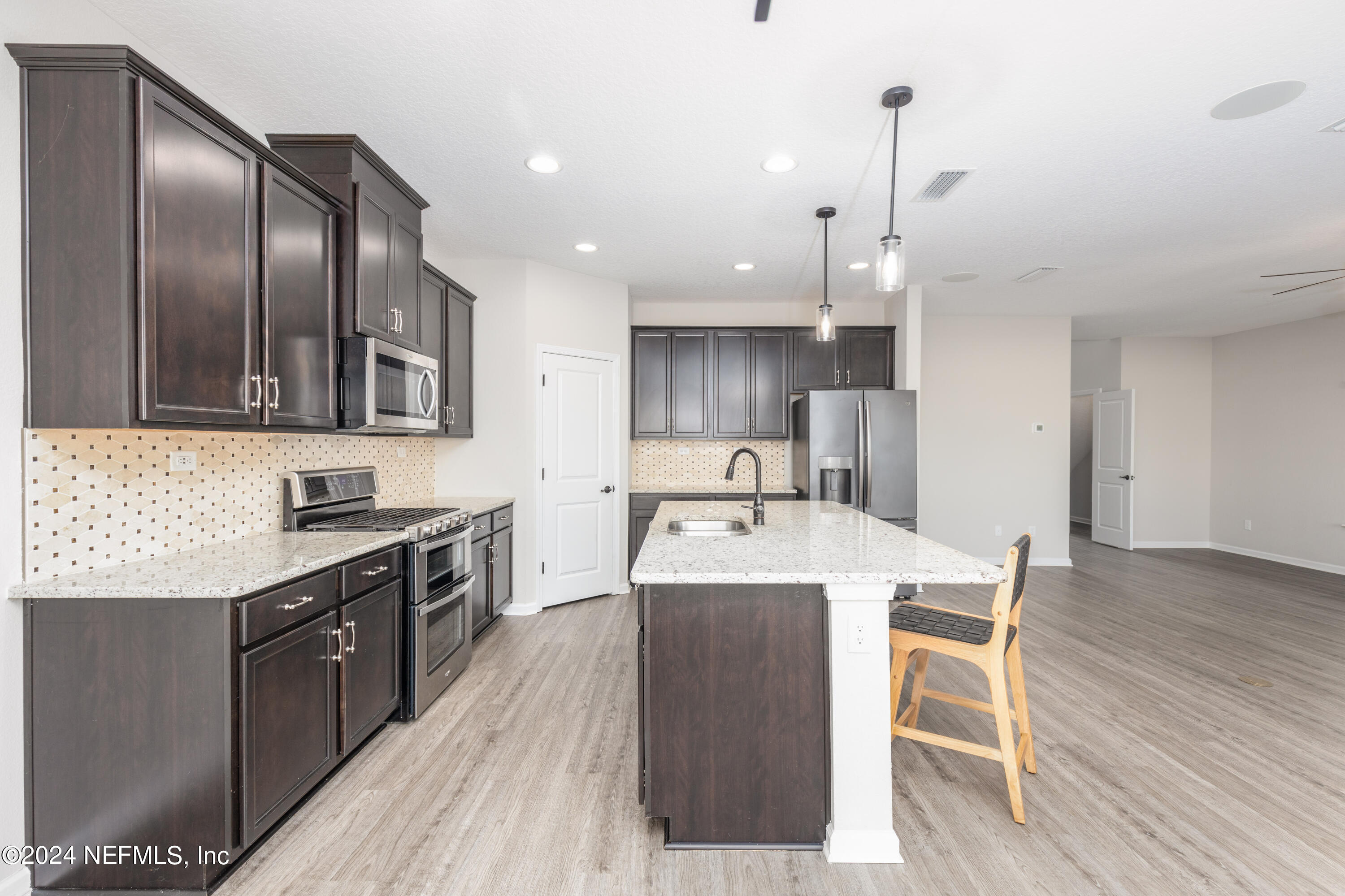 400 Weathered Edge Drive St. Augustine, FL 32092 - Photo 24 of 35 a large kitchen with stainless steel appliances granite countertop a sink a stove and a wooden floors