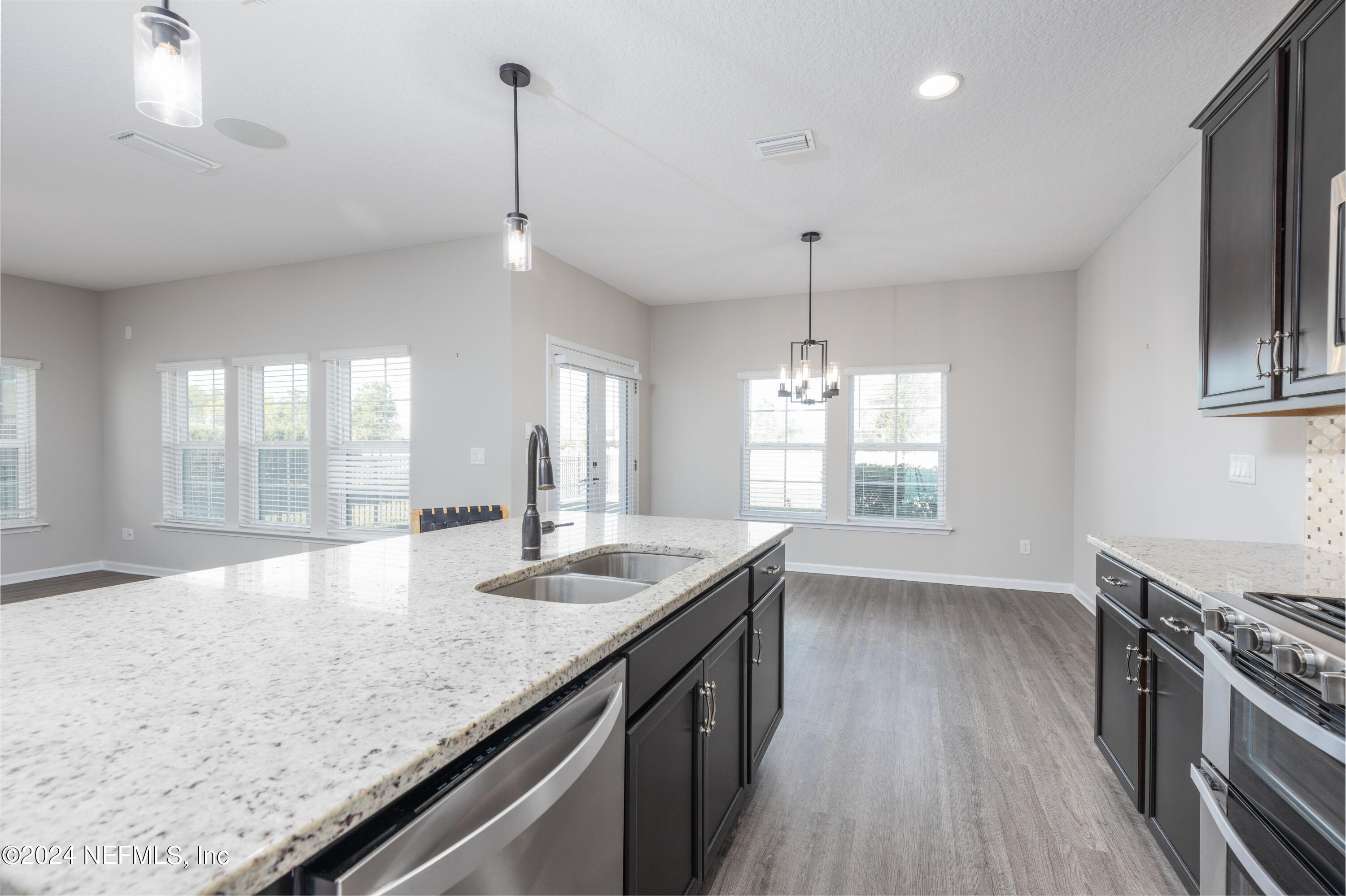 400 Weathered Edge Drive St. Augustine, FL 32092 - Photo 26 of 35 a kitchen with stainless steel appliances granite countertop a sink a stove and a wooden floors
