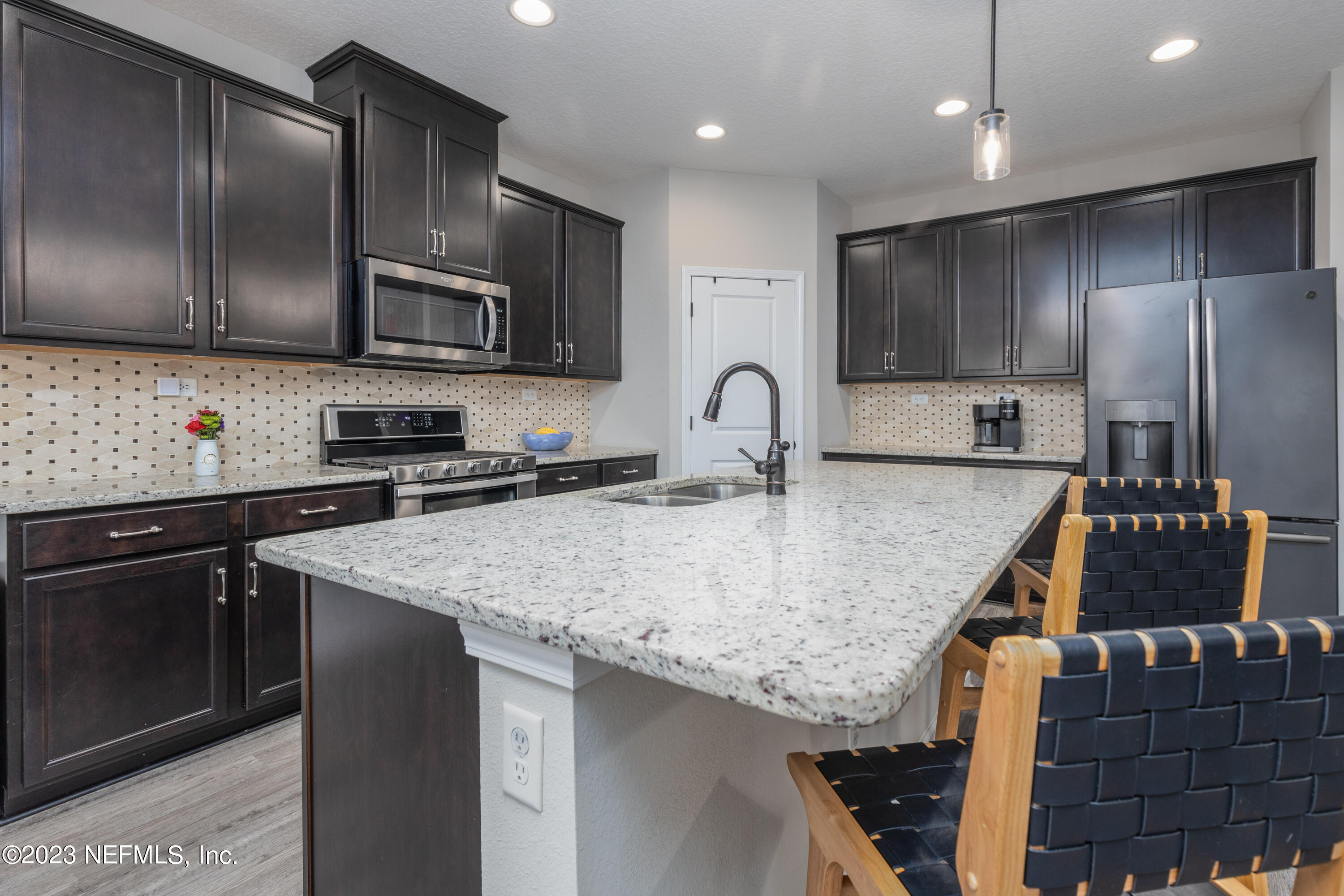 400 Weathered Edge Drive St. Augustine, FL 32092 - Photo 9 of 35 a kitchen with stainless steel appliances granite countertop a sink a microwave and wooden cabinets