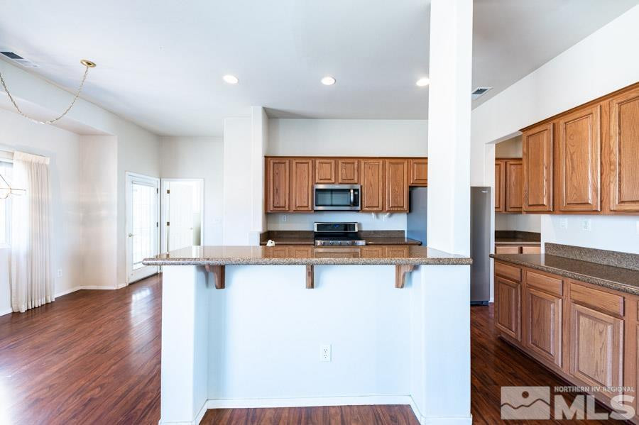 1487 Wild Wolf Way Reno, NV 89521 - Photo 15 of 39 a kitchen with stainless steel appliances a stove top oven a sink a refrigerator and cabinets