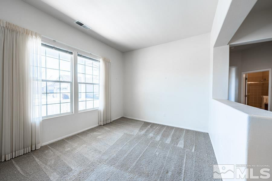 1487 Wild Wolf Way Reno, NV 89521 - Photo 9 of 39 an empty room with wooden floor and windows