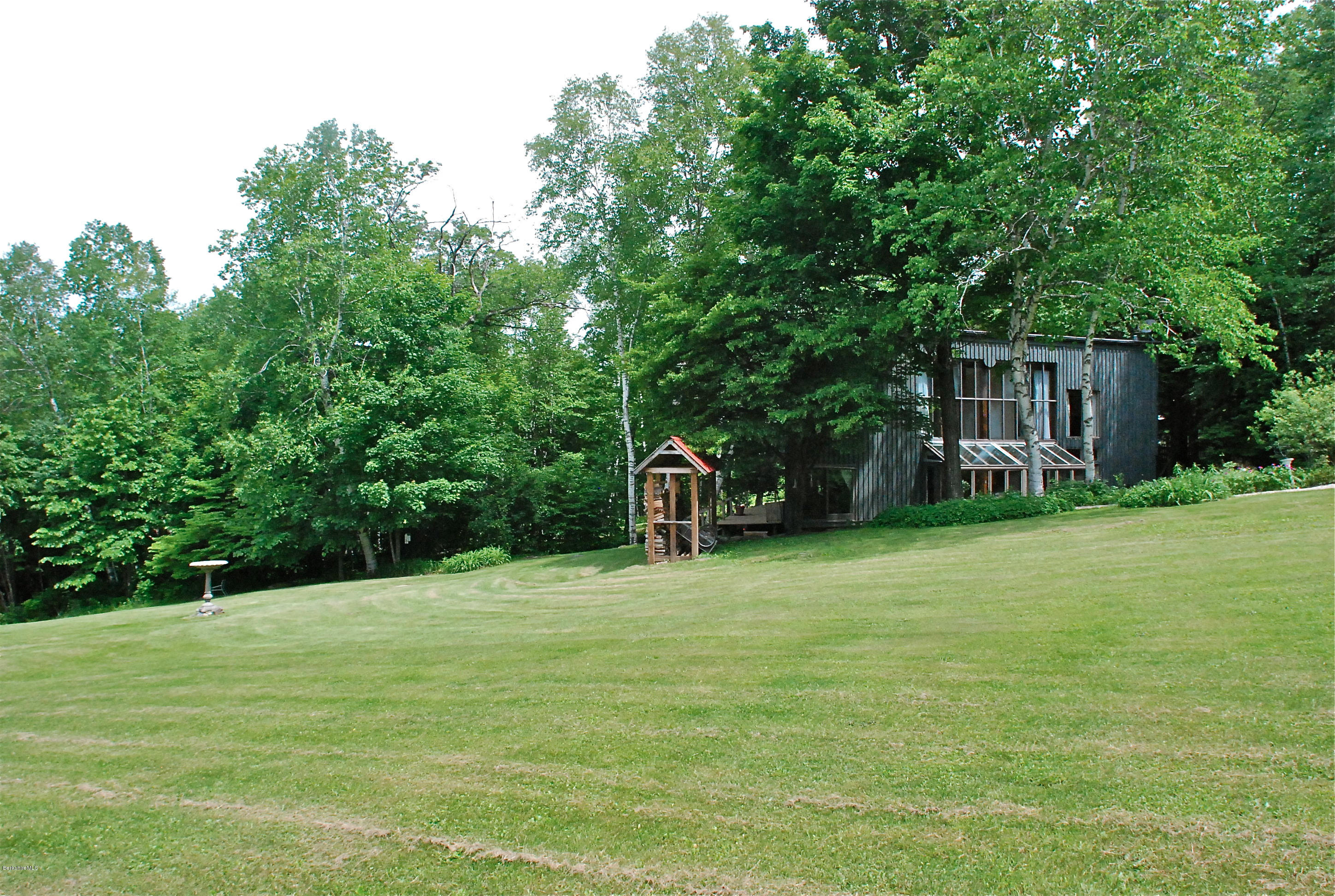 77 Lenox Road West Stockbridge, MA 01266 - Photo 23 of 40 a backyard of a house with plants and large trees