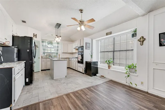 a kitchen with a refrigerator an oven a sink dishwasher and wooden cabinets