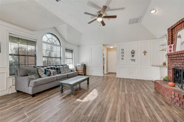 a living room with furniture a fireplace and wooden floor