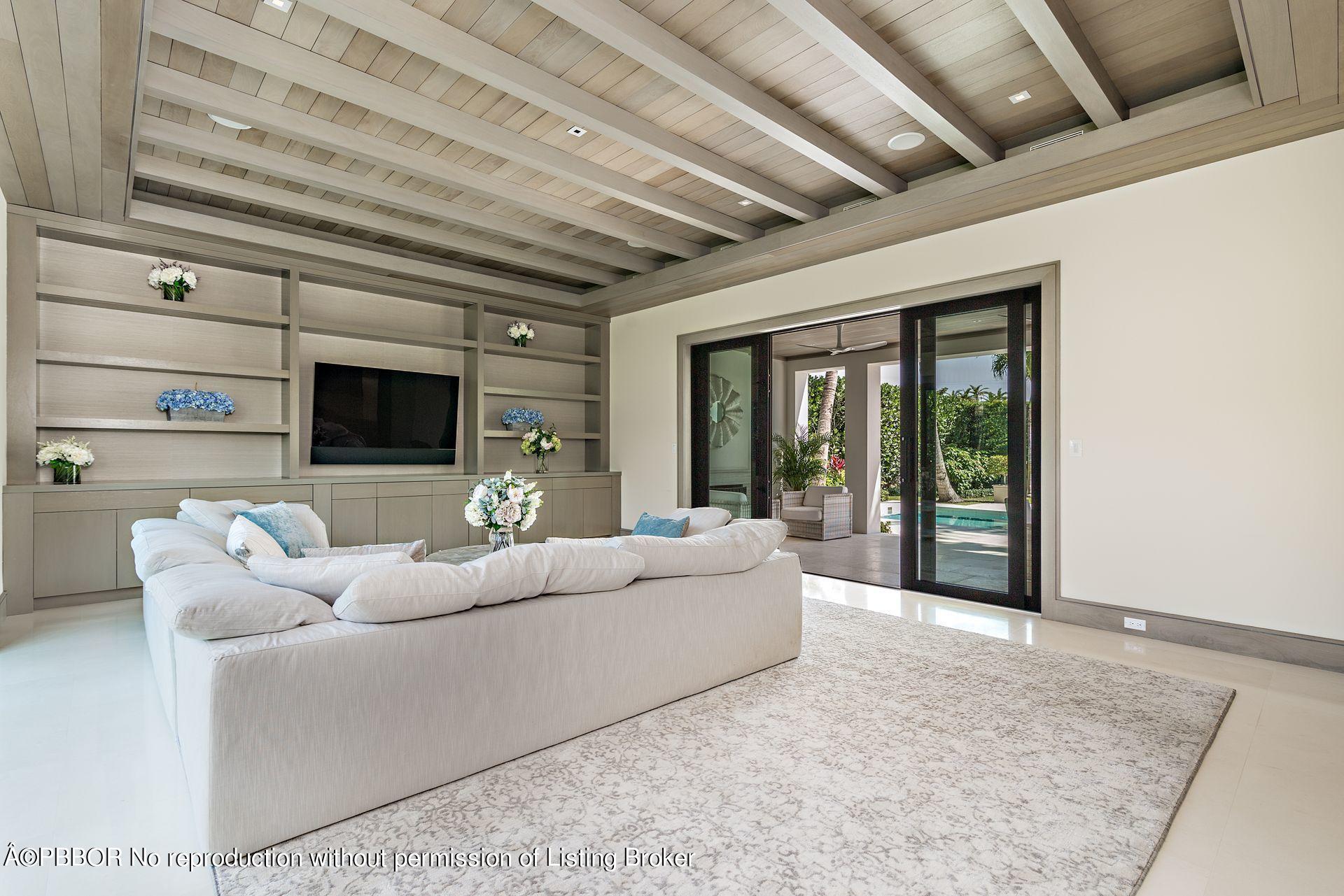 325 Garden Road Palm Beach, FL 33480 - Photo 17 of 57 a living room with furniture a flat screen tv and a floor to ceiling window