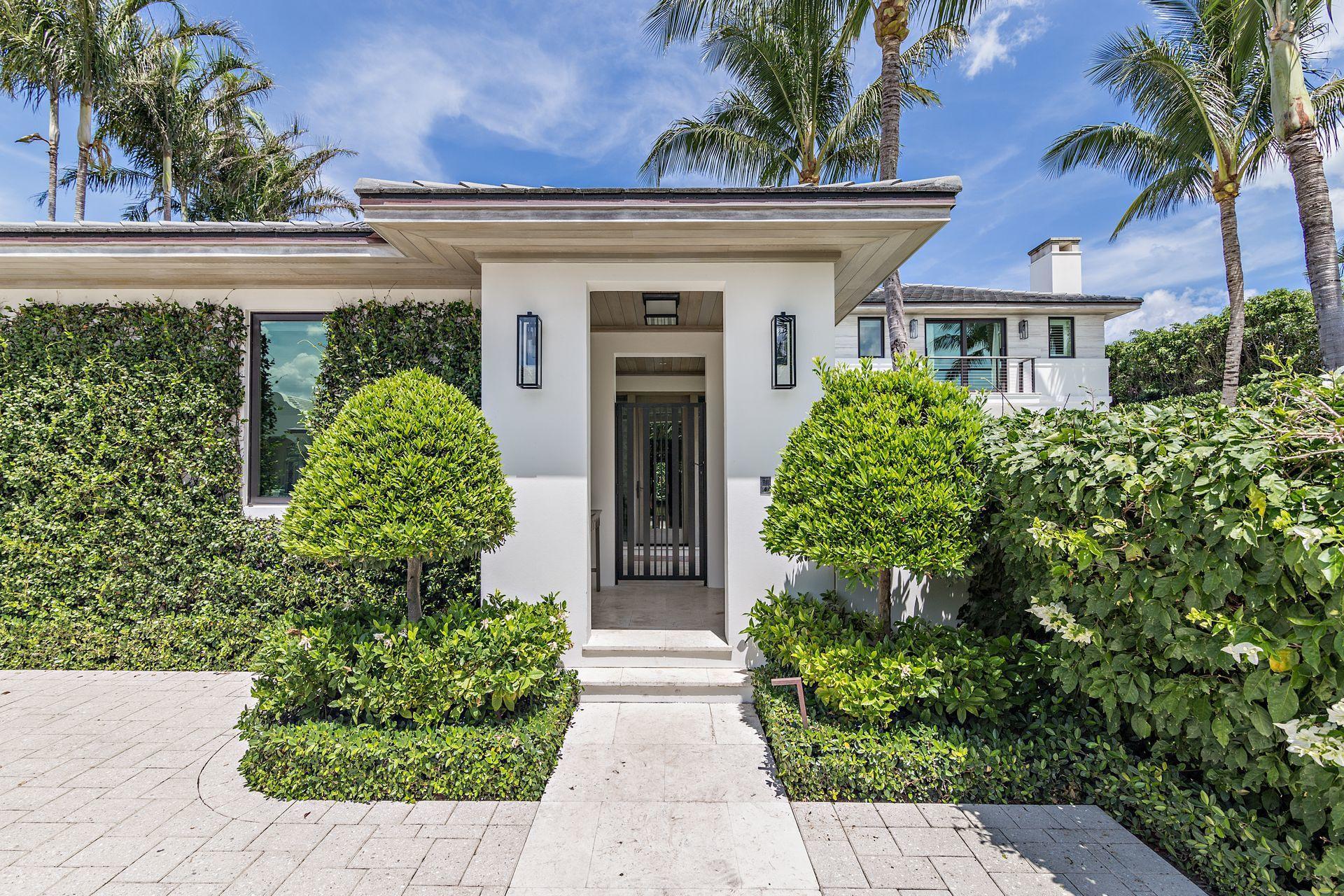 325 Garden Road Palm Beach, FL 33480 - Photo 3 of 57 a front view of a house with garden