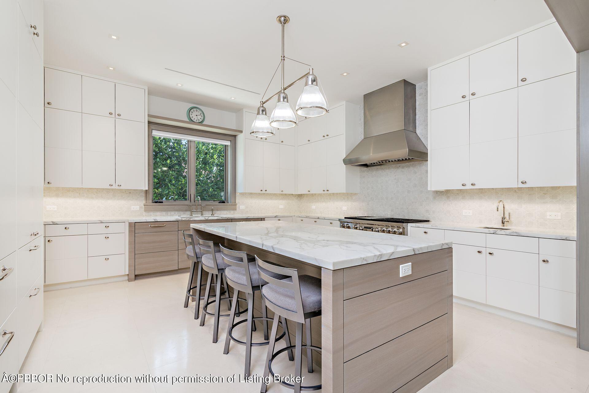 325 Garden Road Palm Beach, FL 33480 - Photo 22 of 57 a kitchen with a stove a chandelier and wooden cabinets