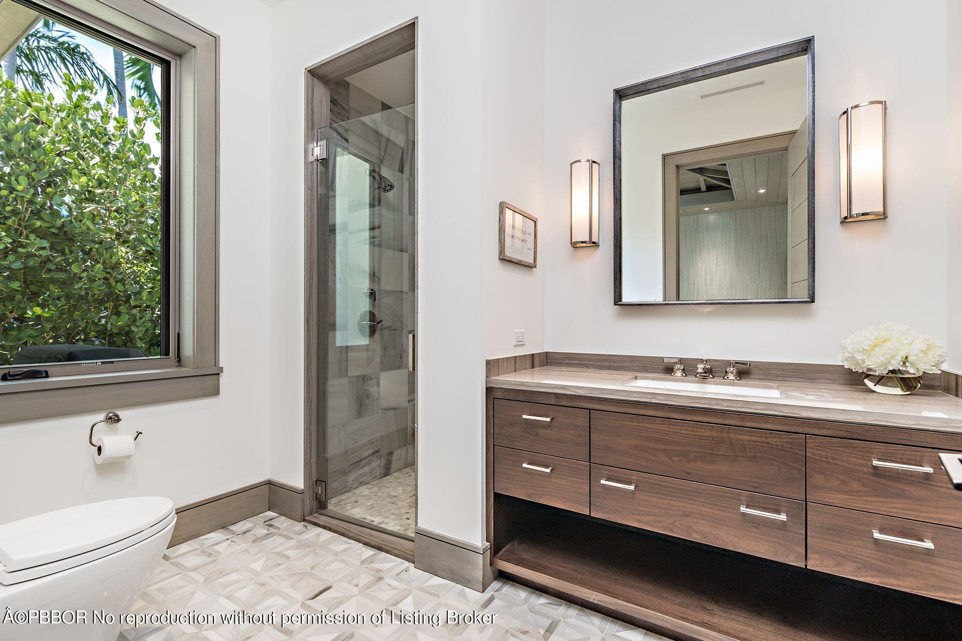 325 Garden Road Palm Beach, FL 33480 - Photo 26 of 57 a bathroom with a toilet a sink and mirror