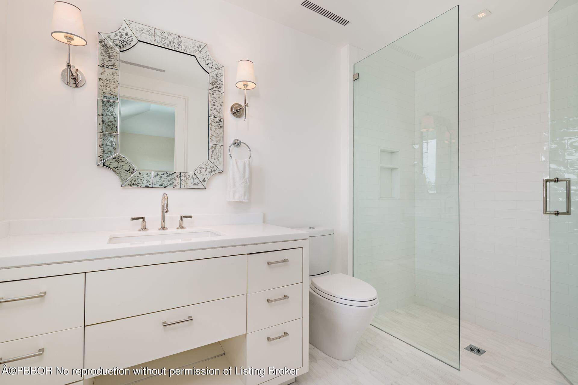 325 Garden Road Palm Beach, FL 33480 - Photo 33 of 57 a bathroom with a toilet a sink and mirror