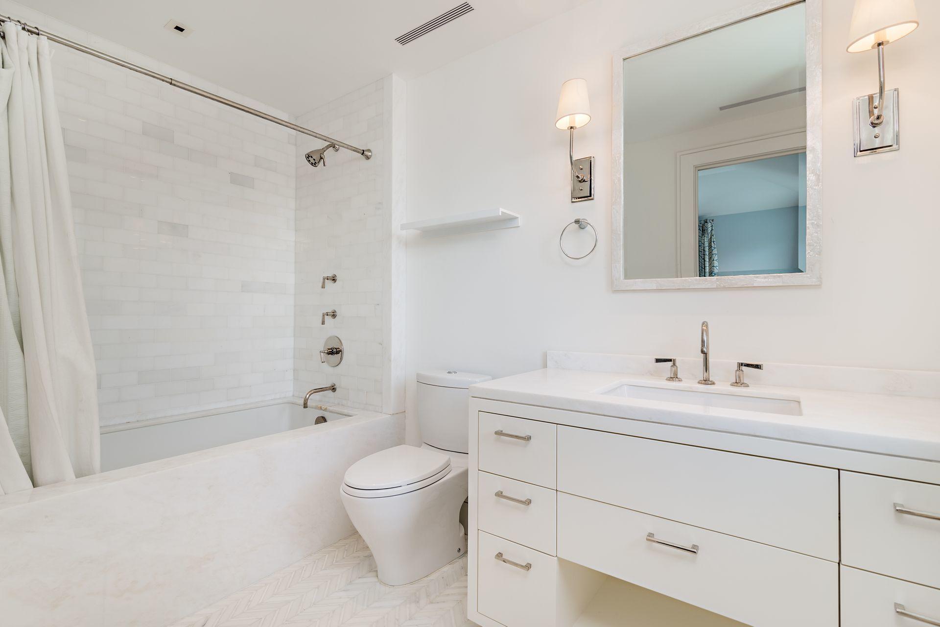 325 Garden Road Palm Beach, FL 33480 - Photo 36 of 57 a bathroom with a toilet a sink a mirror a bathtub and vanity