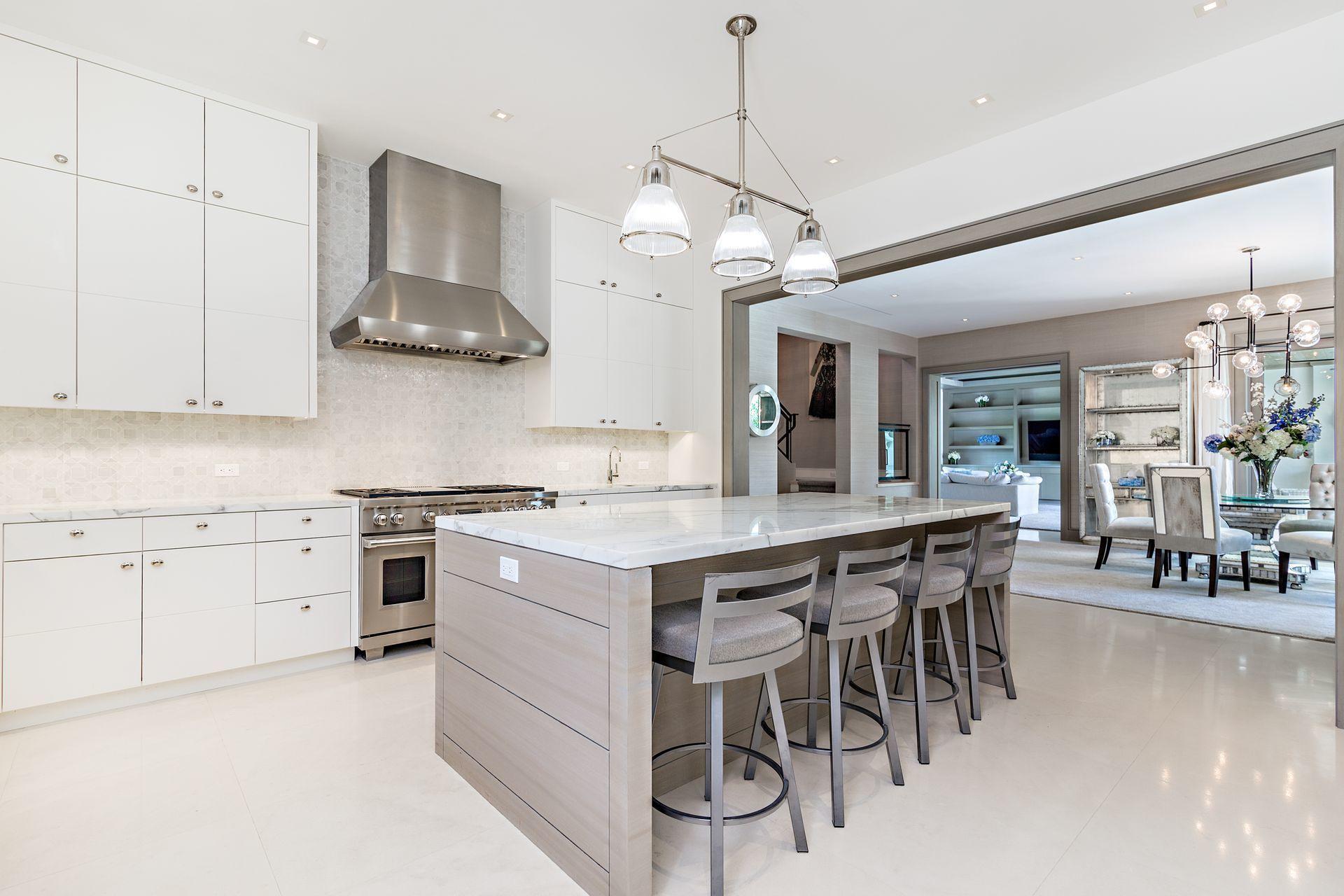 325 Garden Road Palm Beach, FL 33480 - Photo 6 of 57 a kitchen with stainless steel appliances a stove a table and chairs in it