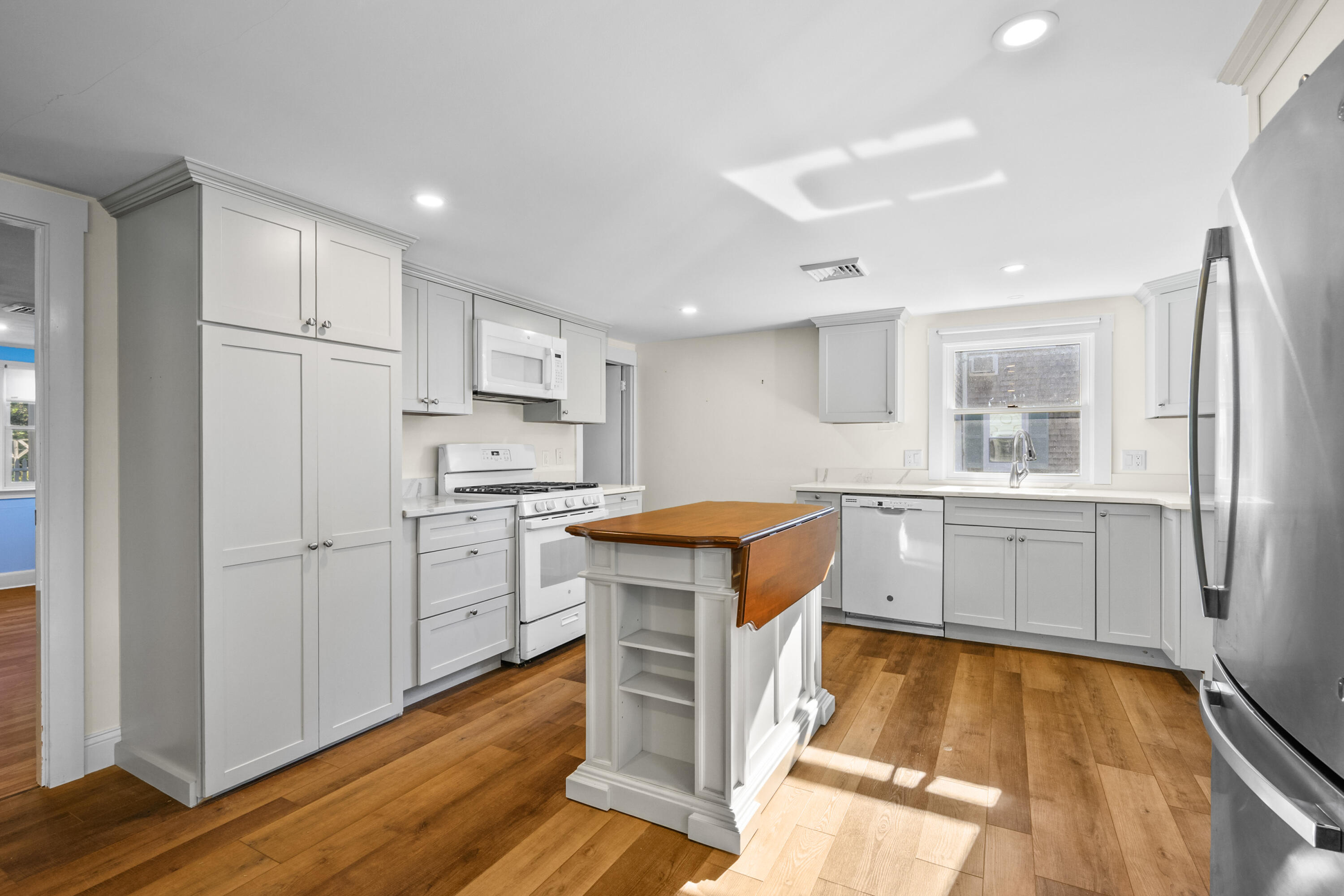 14 Brewster Road West Yarmouth, MA 02673 - Photo 5 of 17 a kitchen with white cabinets and stainless steel appliances