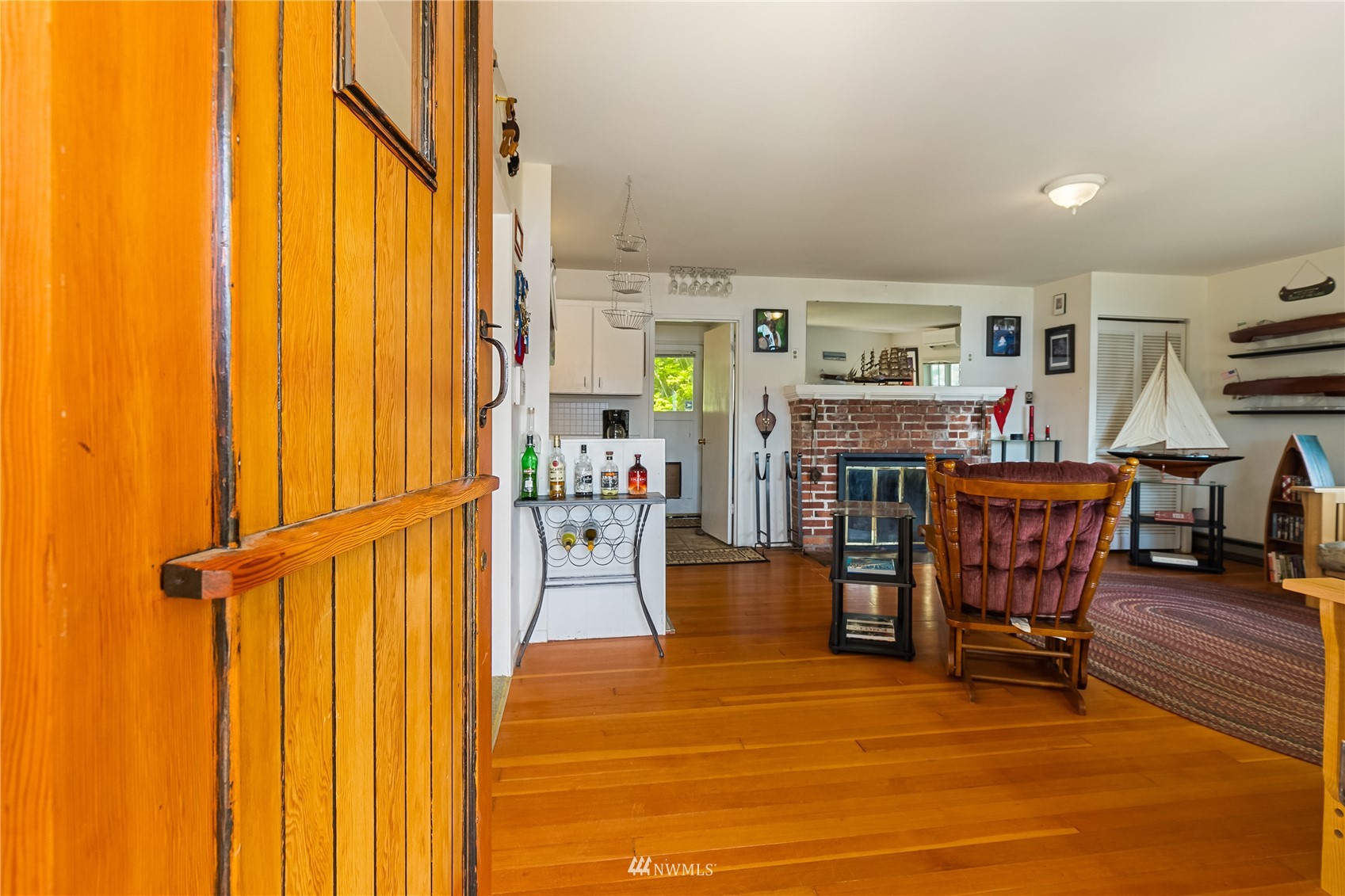 2964 North Shore Road Bellingham, WA 98226 - Photo 14 of 40 a living room with furniture a fireplace and a dining table with wooden floor