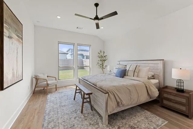 a bedroom with a bed and a potted plant on the dresser