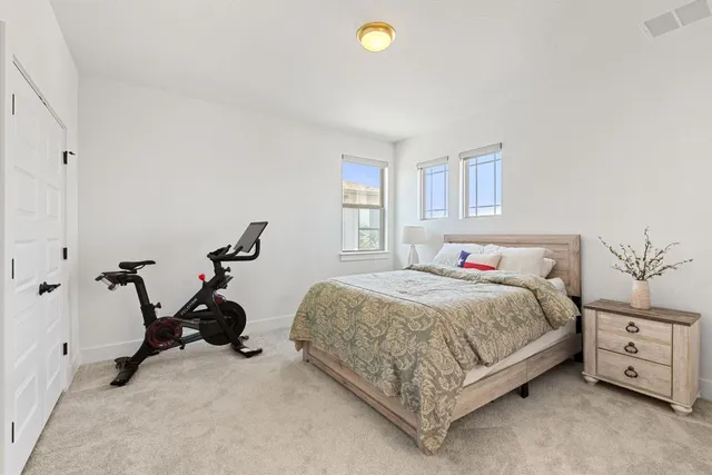 a bedroom with a large bed and a chandelier