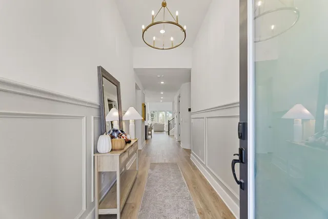a hallway with a view of living room and wooden floor
