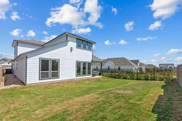 a view of a big house with a big yard and potted plants