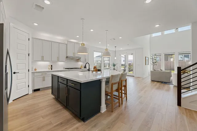 a kitchen with stainless steel appliances a stove a table and chairs refrigerator