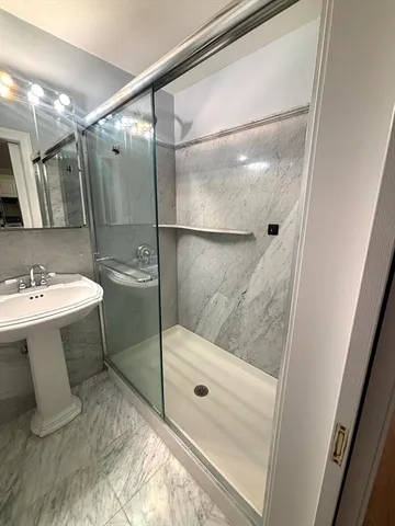 a bathroom with a sink mirror and shower