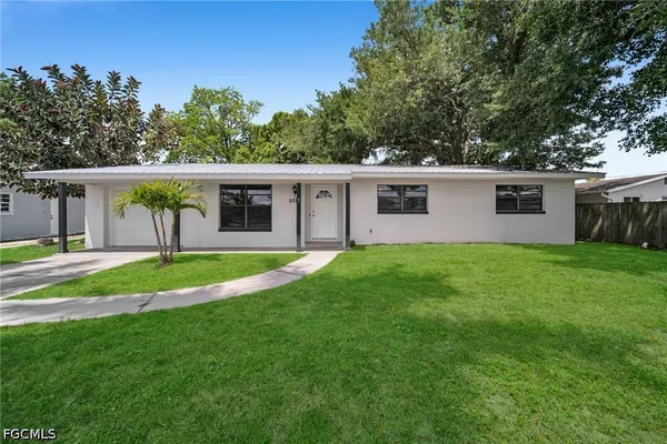 a view of a house with backyard and a tree