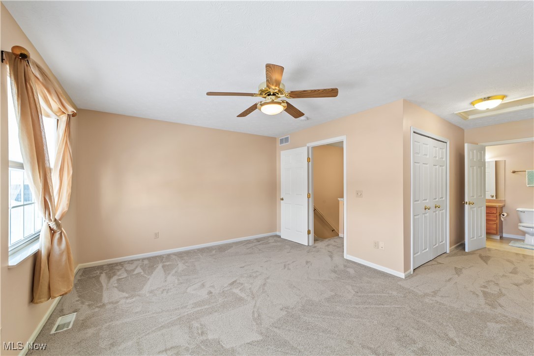 4364 Sexton Road Cleveland, OH 44105 - Photo 20 of 50 Unfurnished bedroom with ensuite bathroom, light carpet, ceiling fan, and a closet