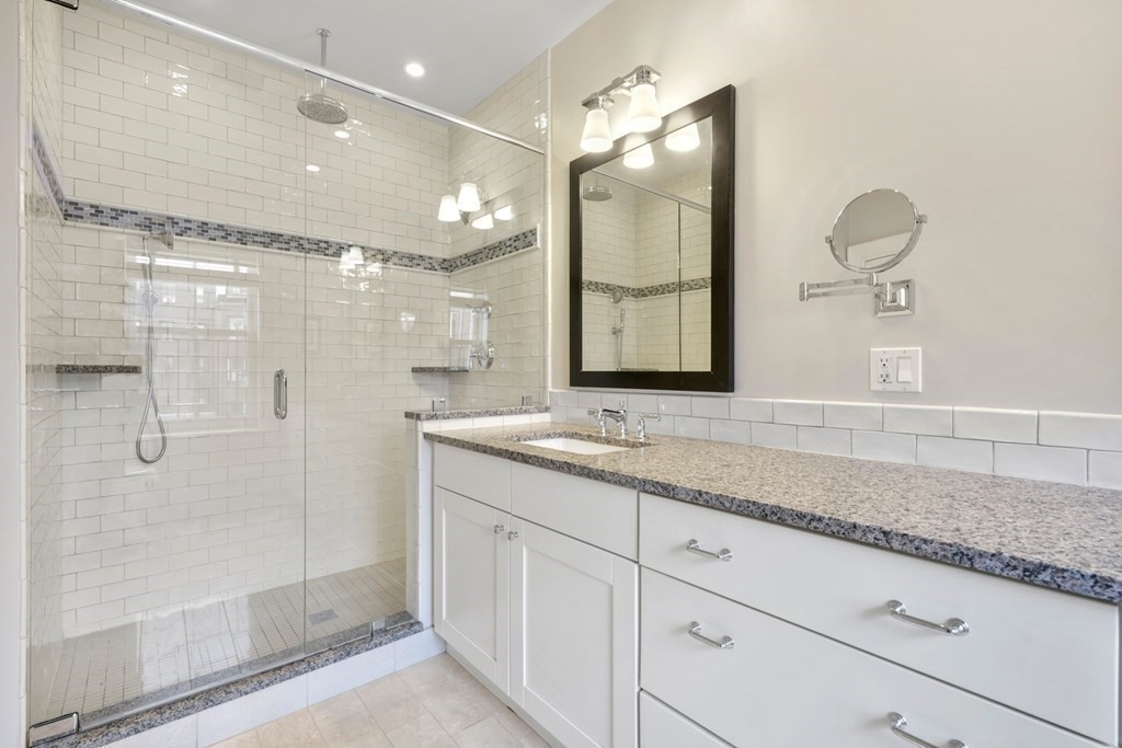 173 Warren Avenue, Unit 2 Boston, MA 02116 - Photo 19 of 32 a bathroom with a granite countertop sink mirror and shower