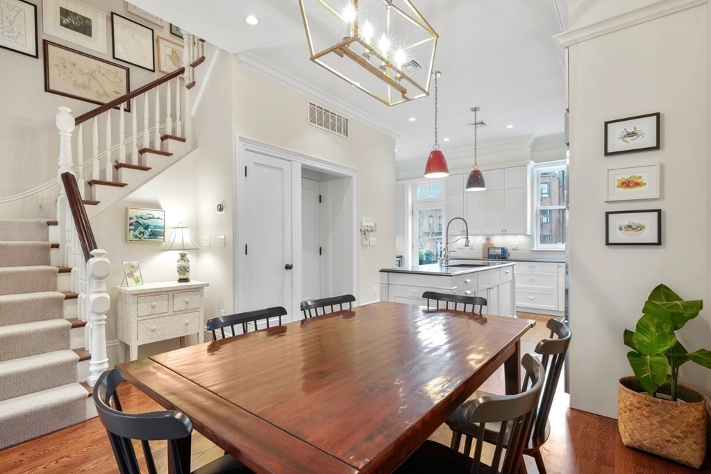 173 Warren Avenue, Unit 2 Boston, MA 02116 - Photo 7 of 32 a dining room with wooden floor a chandelier a wooden table and chairs