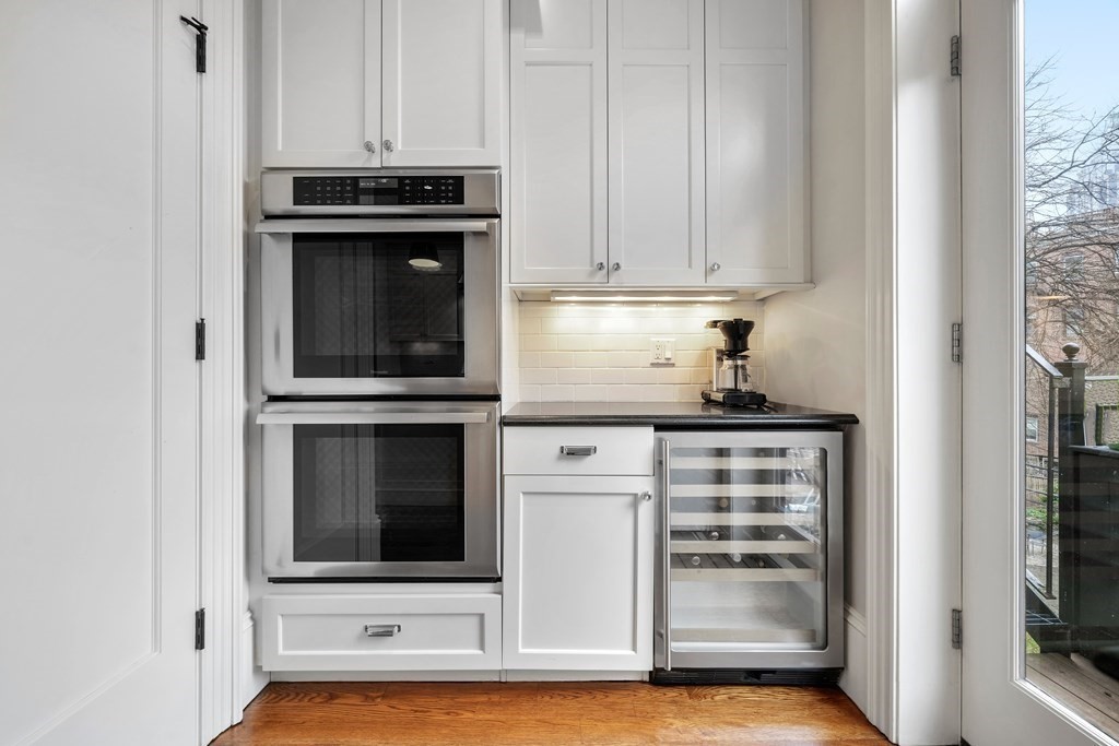 173 Warren Avenue, Unit 2 Boston, MA 02116 - Photo 10 of 32 a kitchen with granite countertop white cabinets and stainless steel appliances