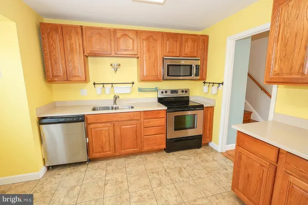 a bathroom with stainless steel appliances granite countertop a refrigerator and a stove