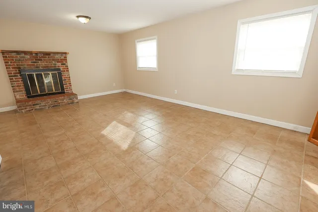 a living room with furniture a fireplace and a floor to ceiling window