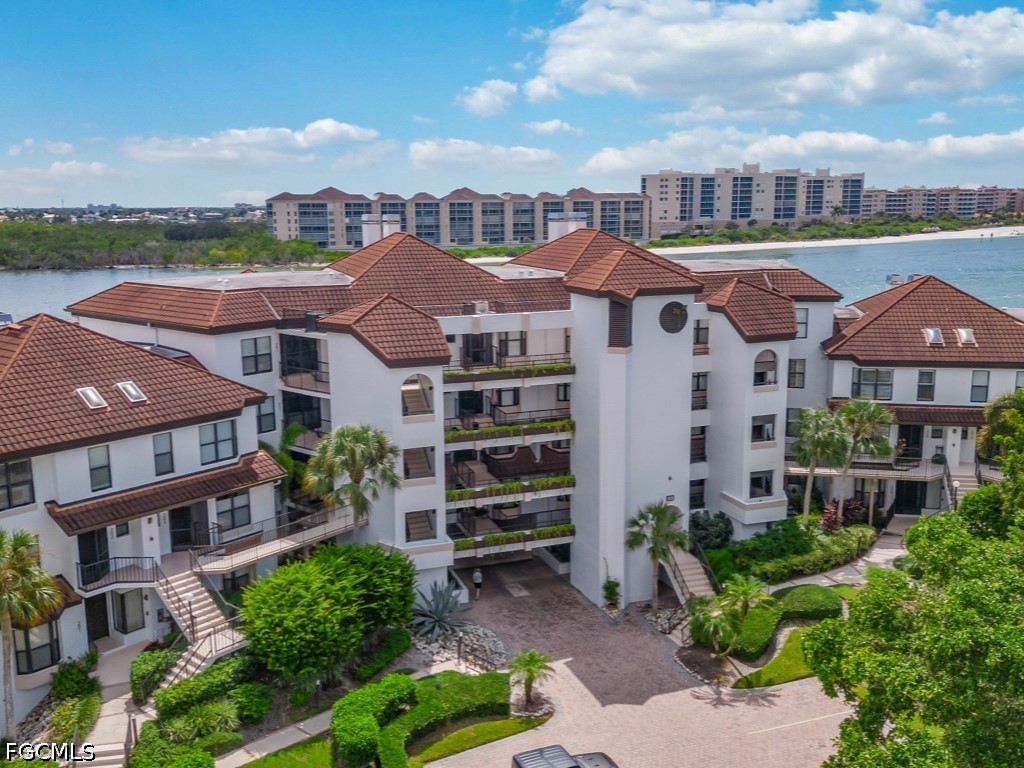 232 La Peninsula Boulevard, Unit 232 Naples, FL 34113 - Photo 29 of 44 a front view of a residential apartment building with a yard