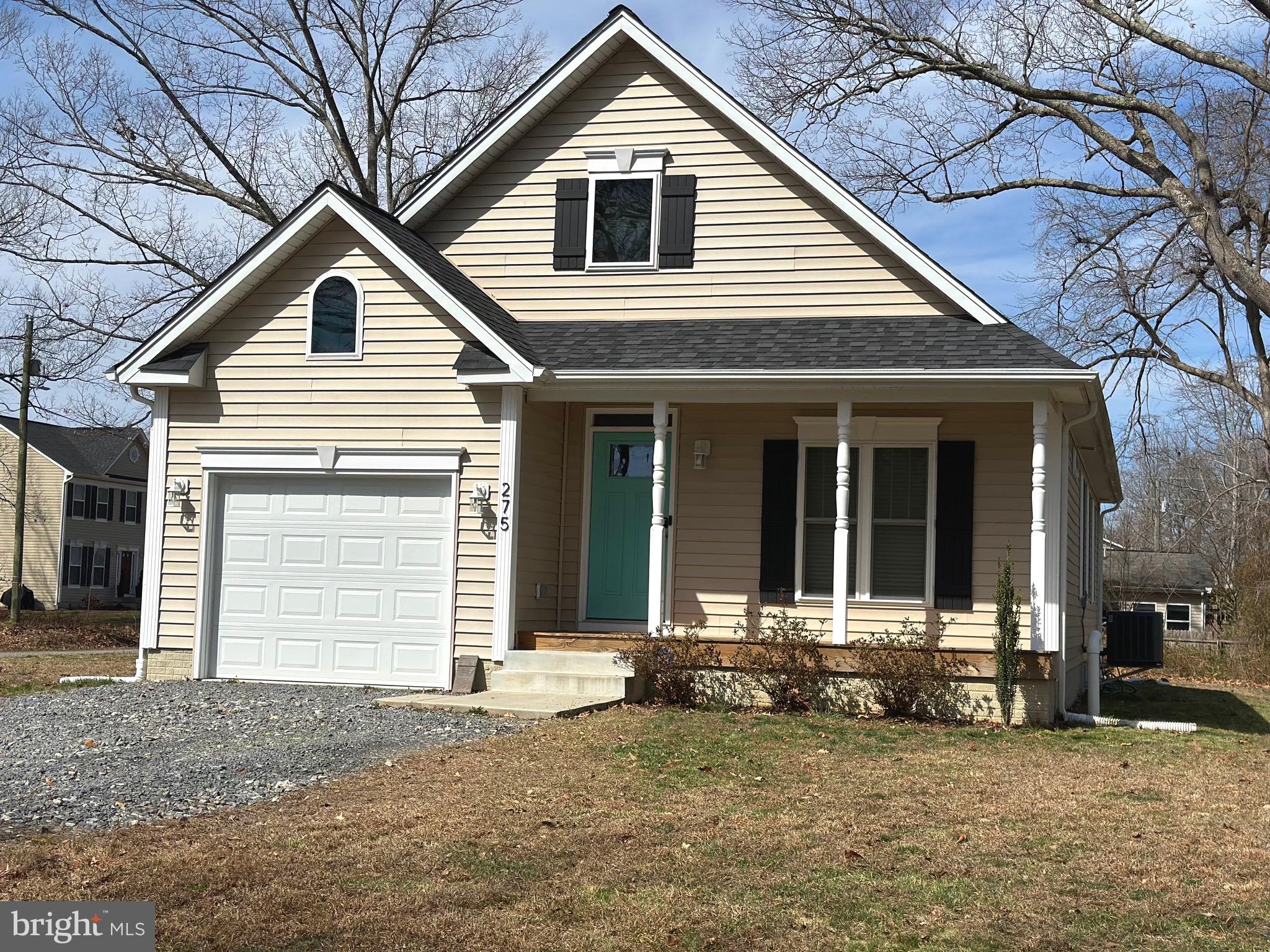 a view of a house with a yard and large tree