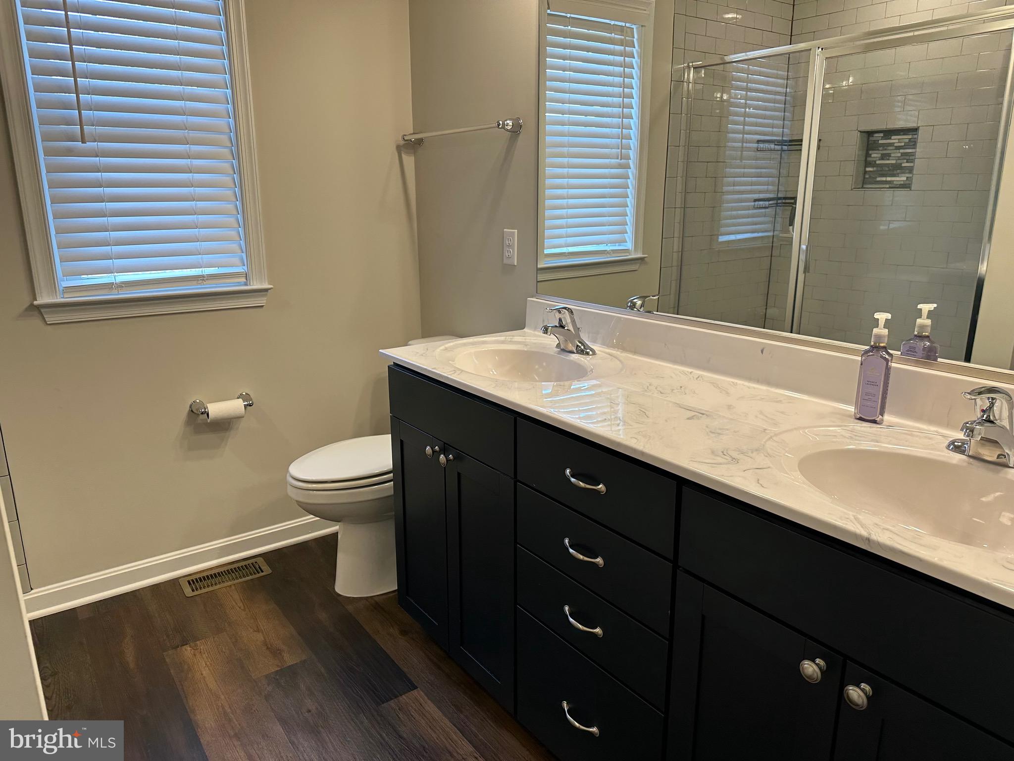 275 Nicholson Drive Colonial Beach, VA 22443 - Photo 13 of 22 a bathroom with a double vanity sink toilet and a mirror