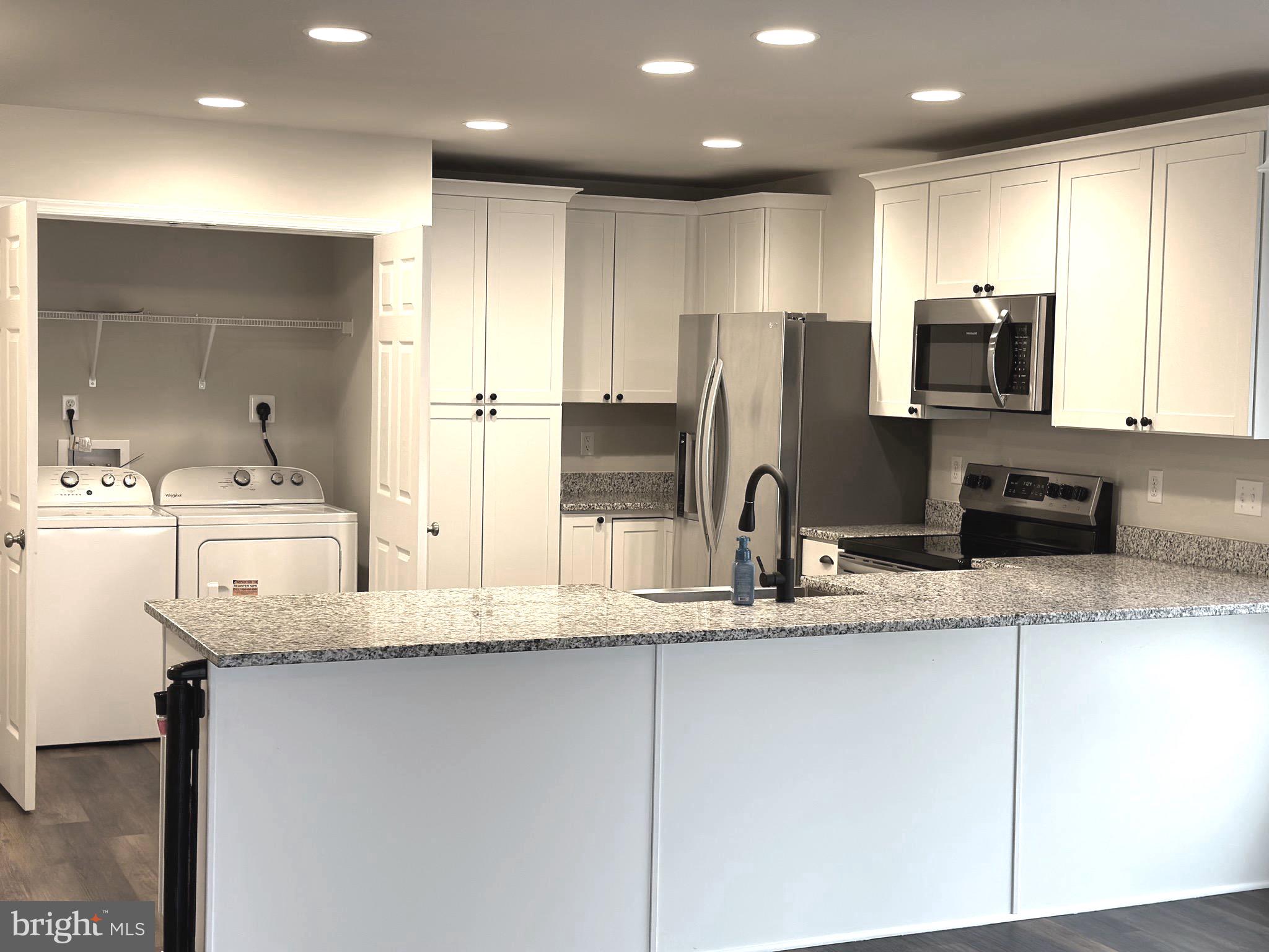 275 Nicholson Drive Colonial Beach, VA 22443 - Photo 4 of 22 a kitchen with stainless steel appliances granite countertop a sink refrigerator and microwave