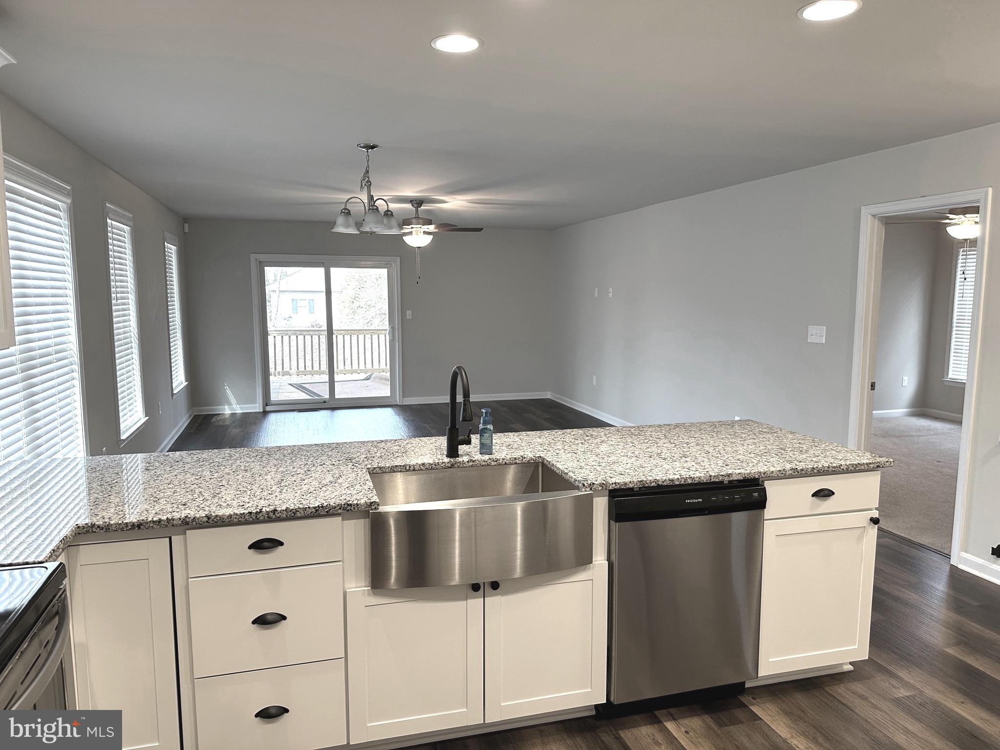 275 Nicholson Drive Colonial Beach, VA 22443 - Photo 7 of 22 a kitchen with granite countertop a sink and dishwasher with wooden floor