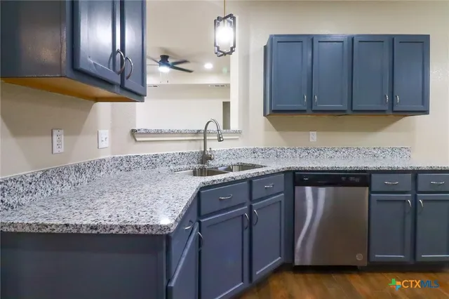 a kitchen with granite countertop wooden cabinets and a sink